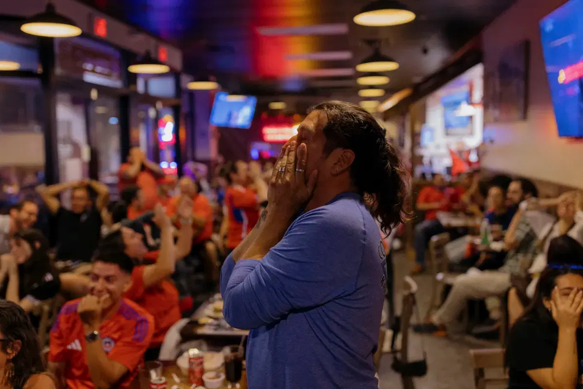 A person covers their face after Argentina scored a goal. 