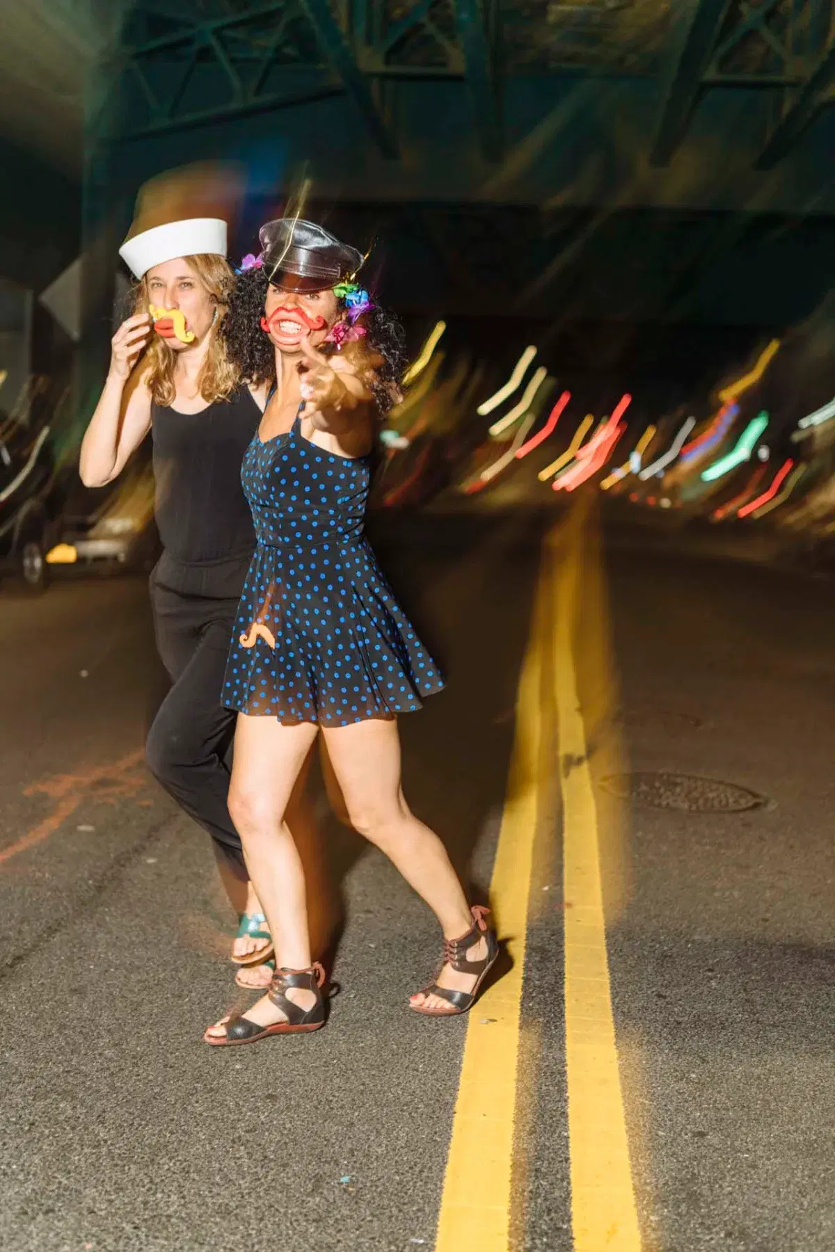 People wearing hats crossing street at night