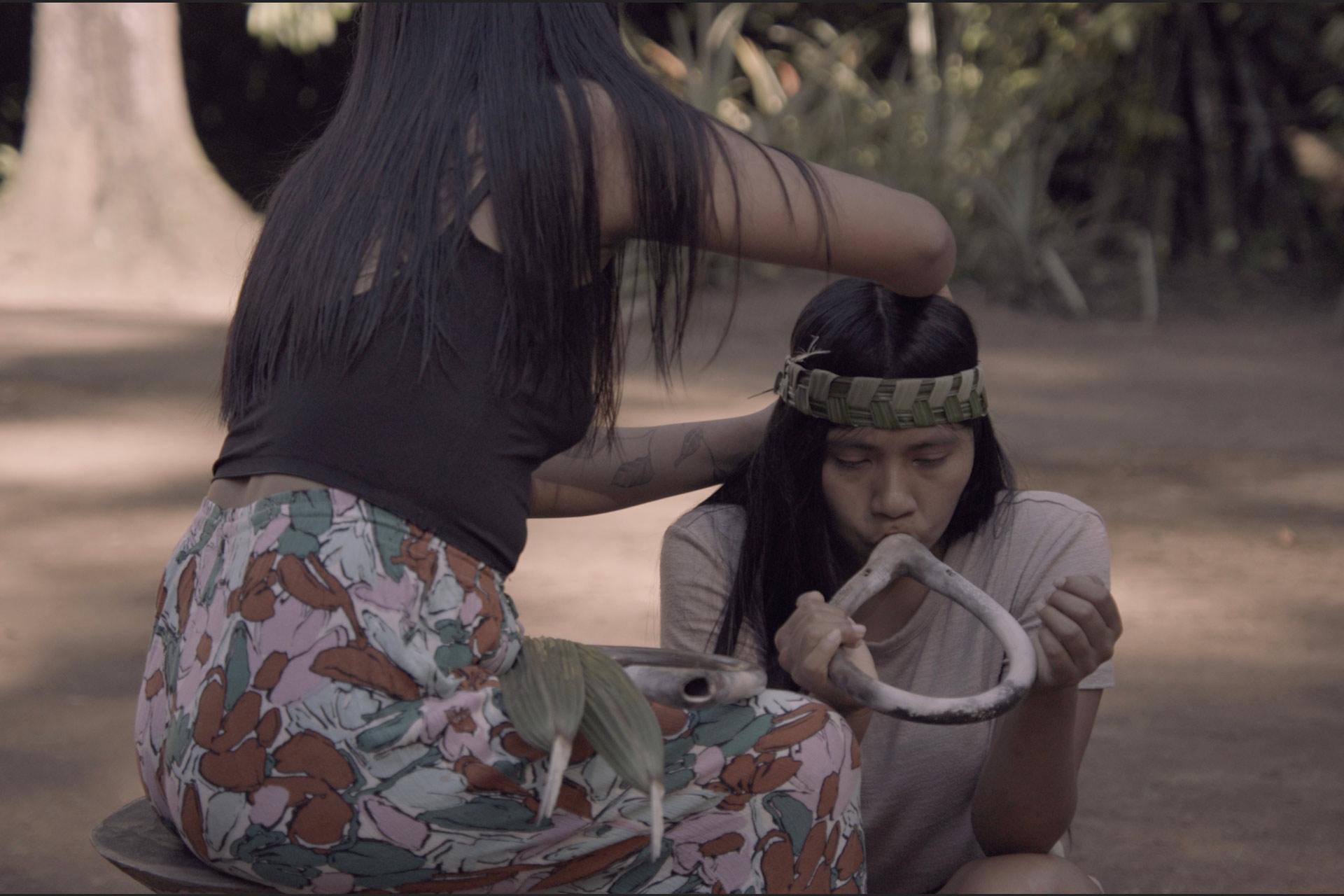 Two people carry ancient sound instruments.