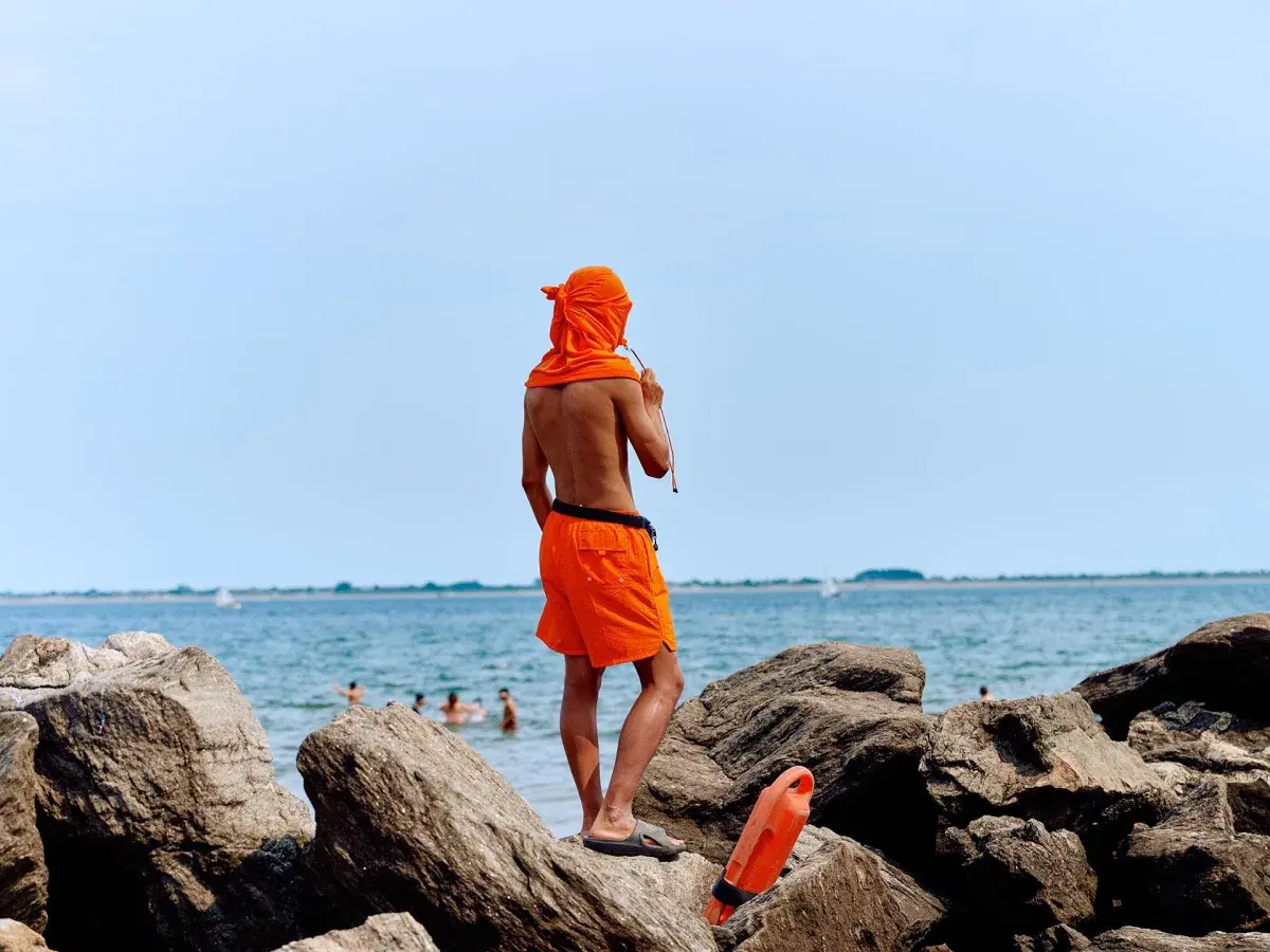 A lifeguard stands on a rock at Brighton Beach in Brooklyn. 