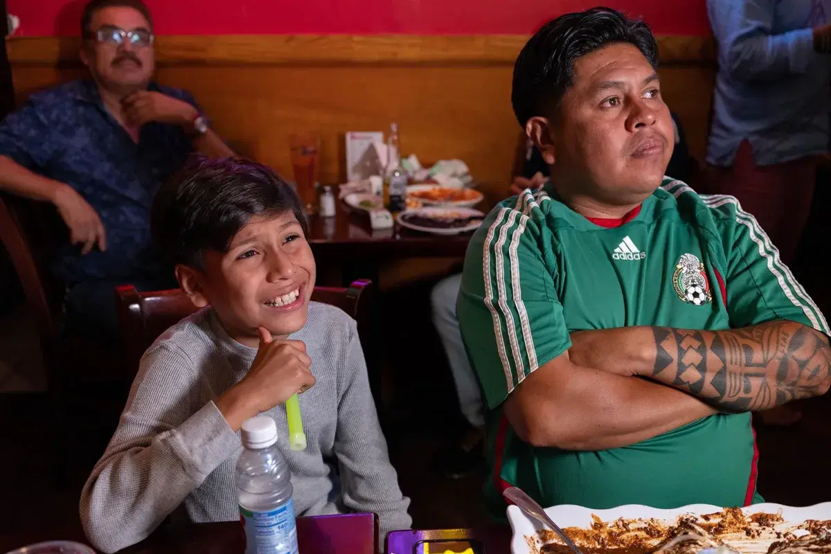 A young person and their parent watch the Mexico vs Ecuador game at Xochimilco.