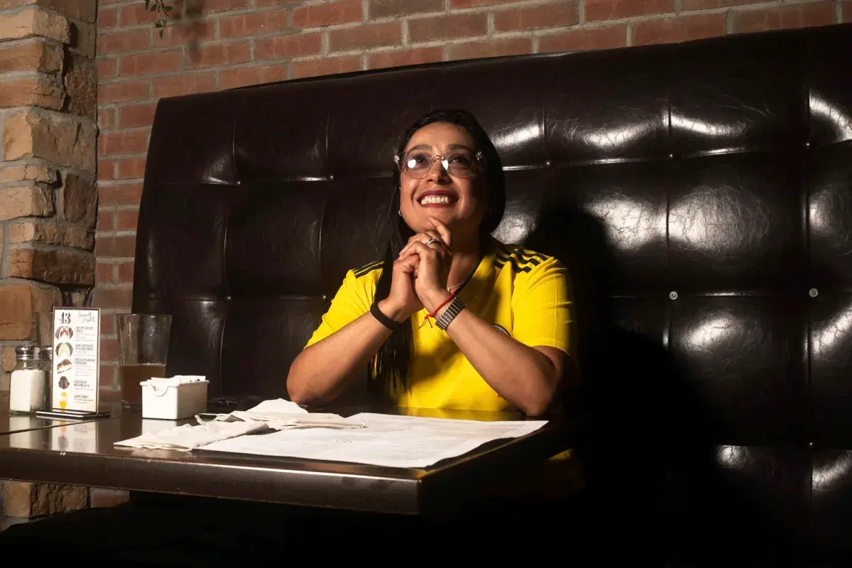 A person smiles while watching Colombia’s game against Costa Rica at Bar 43 in Queens. 