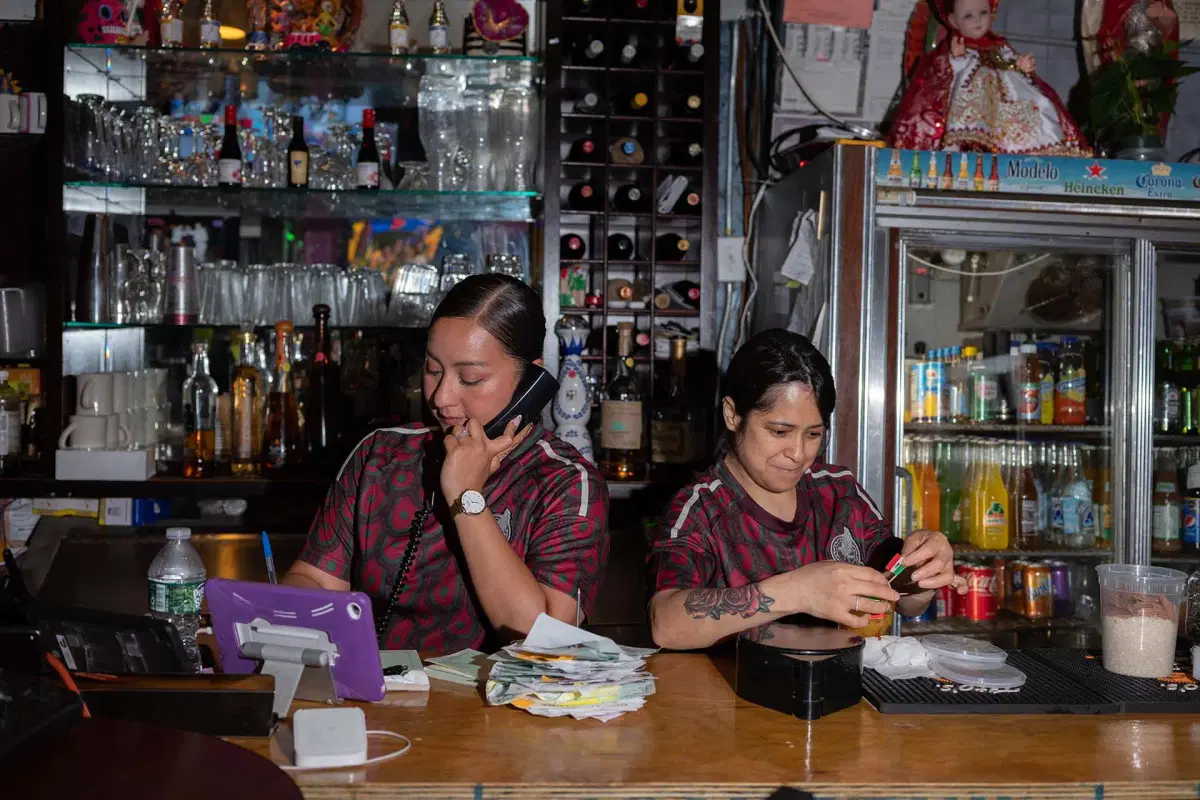 Two people take orders on the phone at Xochimilco. 