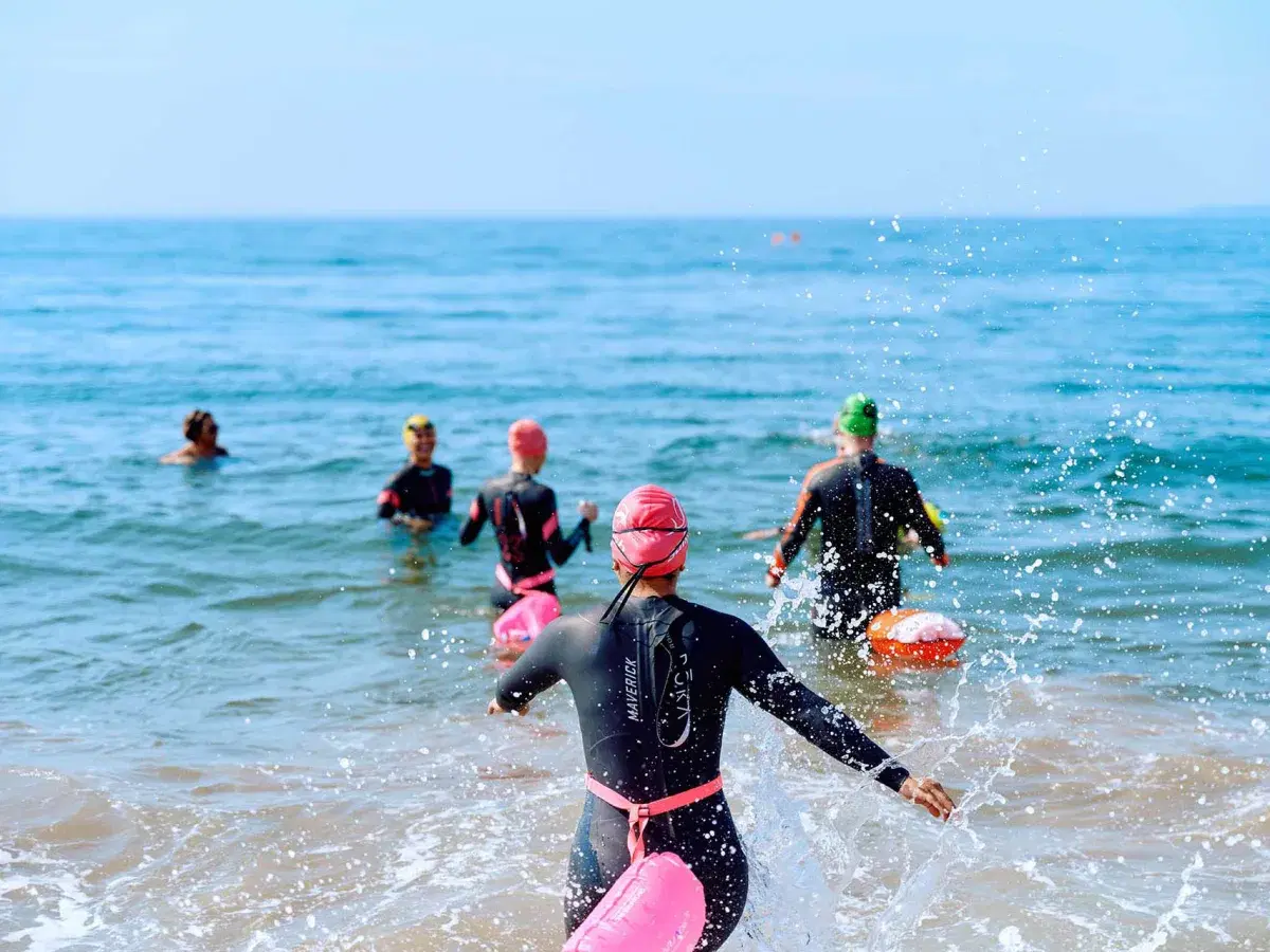 People swim in open water at Brighton Beach in Brooklyn.