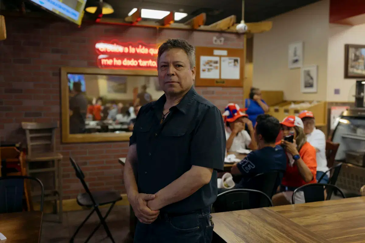 Pablo Colque poses for a photo in his restaurant. 