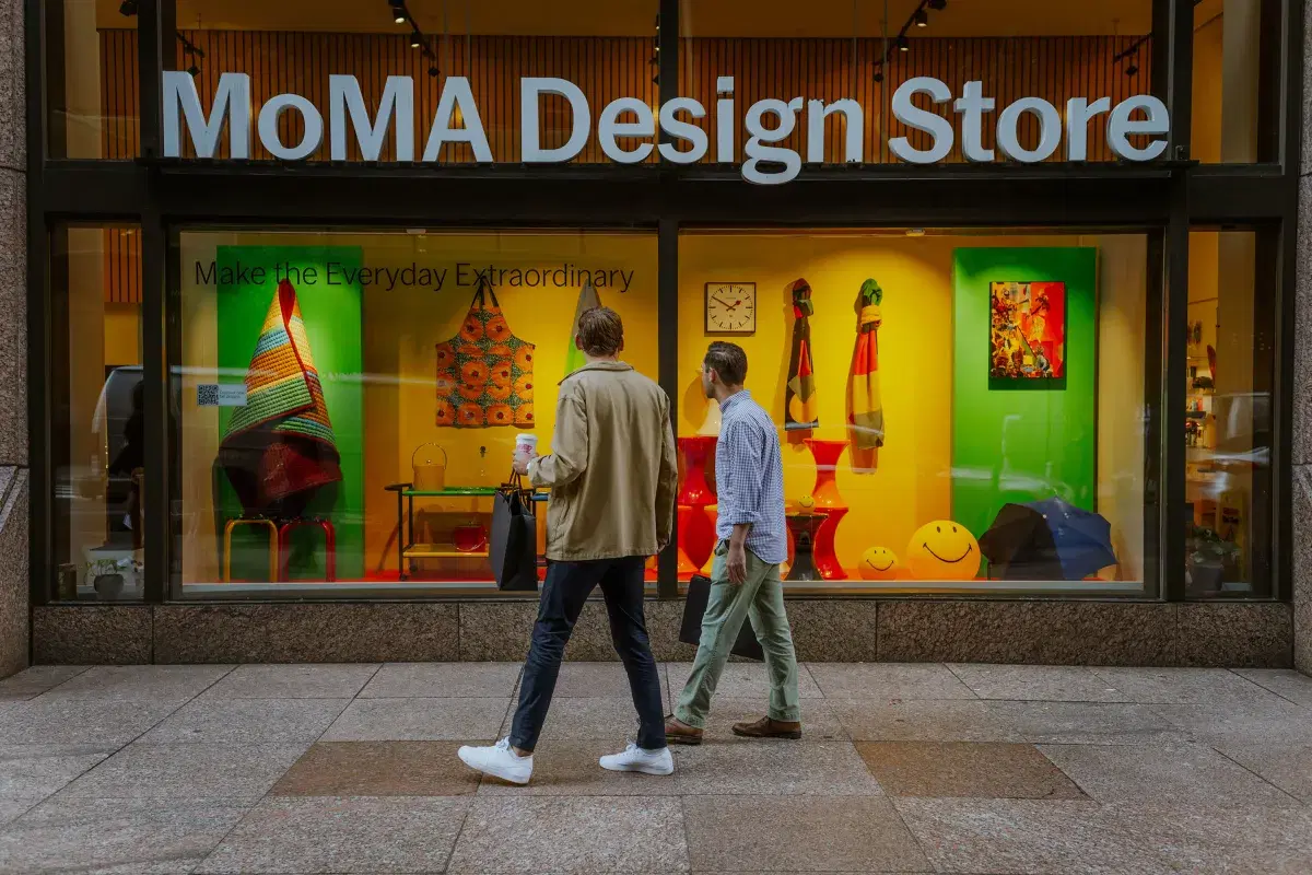 Two people look at the MoMA Design Store, exterior 