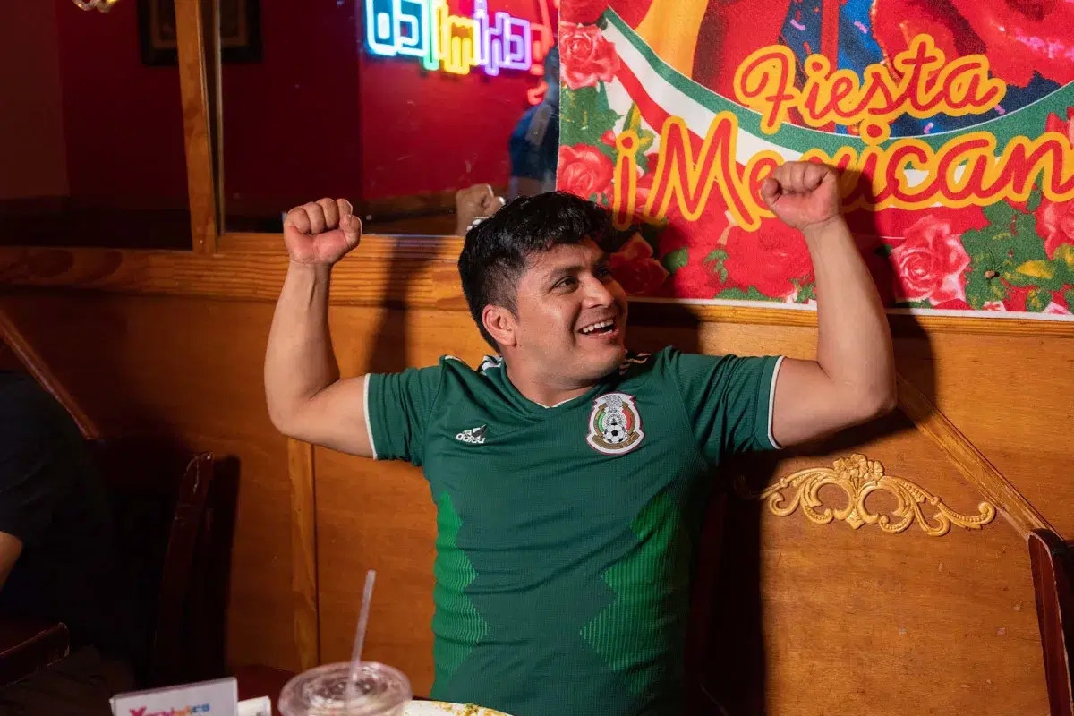 A person cheers while watching the Mexico vs Ecuador game 