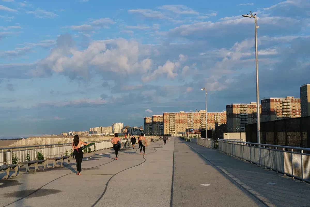 People walk on the boardwalk at Rockaway Beach in Queens. 