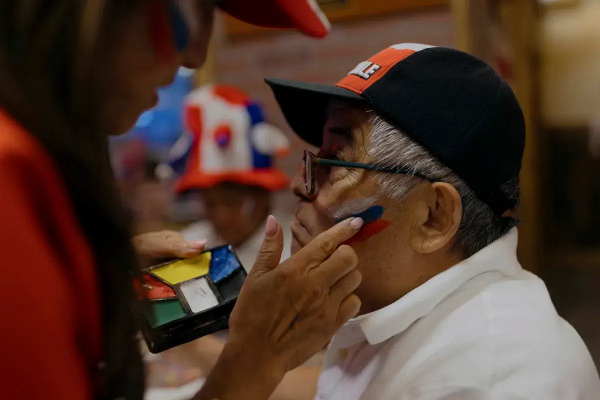 The Chilean colors are applied to a person's cheek.