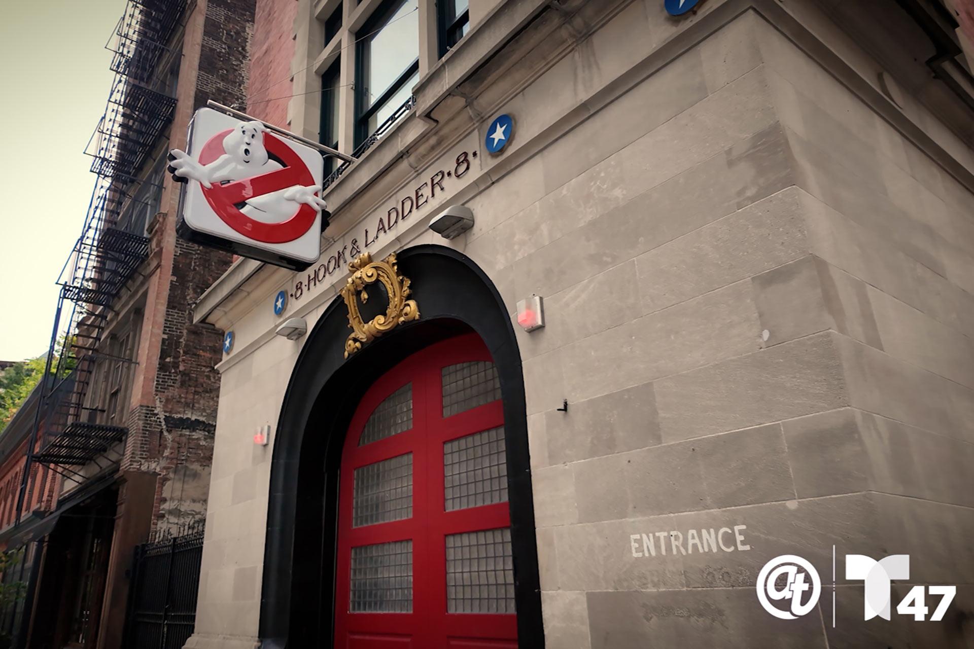 A view of the entrance to Hook & Ladder 8 firehouse in New York City, featuring the Ghostbusters logo sign above the red doors and the word “ENTRANCE” painted on the wall.
