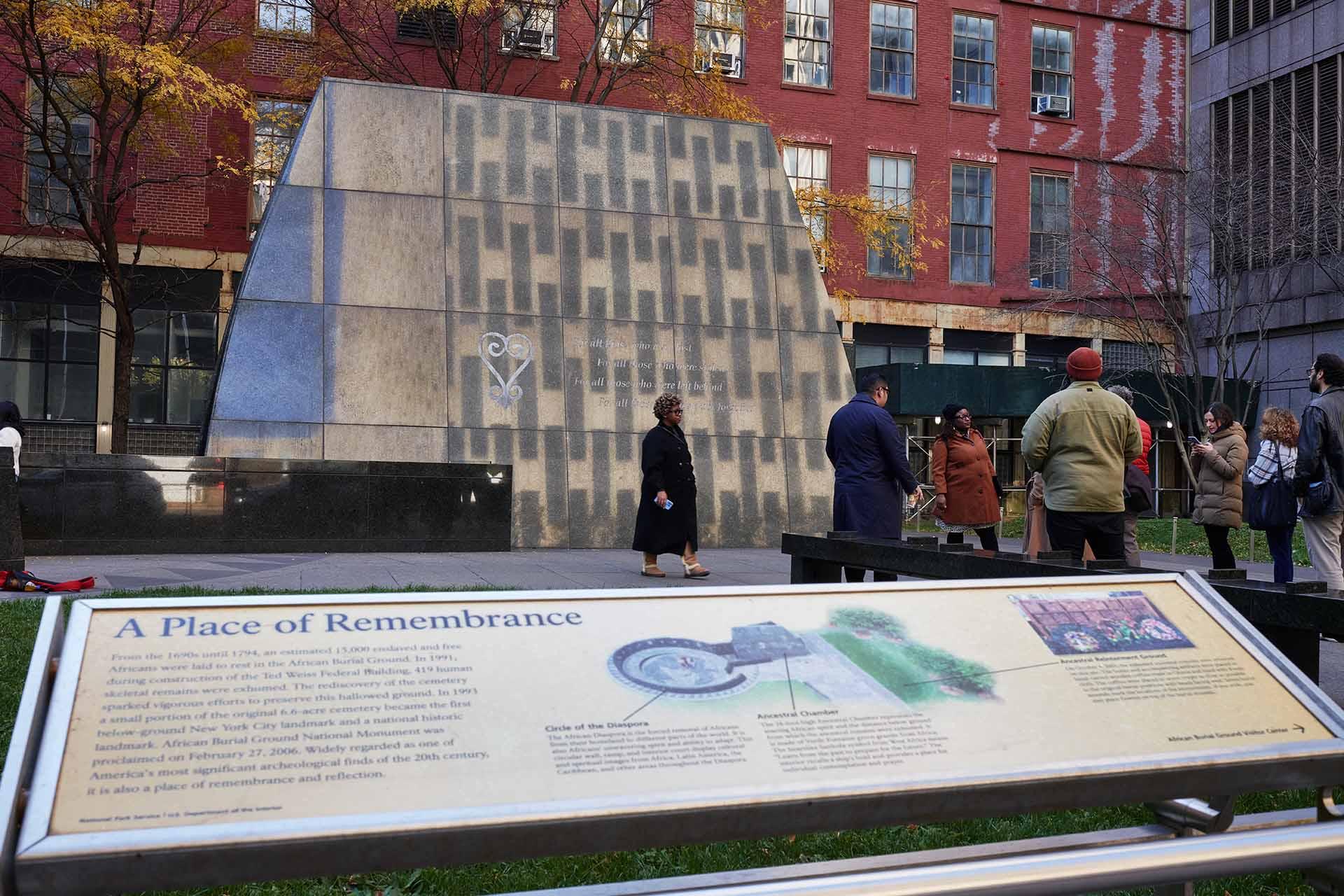 People are gathered around the African Burial Ground National Monument.